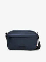 Bandolera Tommy Hilfiger azul marino con correa ajustable de tejido trenzado, cierre de cremallera, bolsillo exterior con cremallera y logo texturizado en la parte delantera.