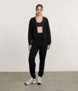 Campera deportiva color marrón, con capucha ajustable mediante cordón con lettering estampado, cierre frontal por cremallera, mangas largas con puños ajustados, bolsillo canguro y recorte en la espalda.