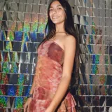 Top strapless de tela liviana con estampado tie-dye en tonos rojizos, marrones y rosados. Presenta un ruedo asimétrico con volados y espalda elastizada.