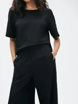Pantalón negro de corte ancho con cintura elástica.
