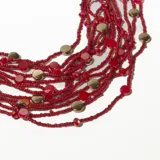 Collar corto de múltiples hilos de cuentas rojas con detalles de discos dorados.