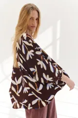 Camisa marrón con estampado de hojas blancas y azules, corte holgado, cuello mao, manga 3/4 y cierre frontal con botones.