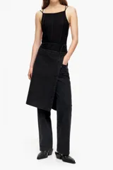 Conjunto de denim negro lavado compuesto por pantalón recto de tiro bajo con cierre de cremallera y falda pareo midi sobrepuesta.