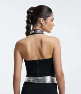 Blusa cropped negra de bengalina, con escote halter con lentejuelas y cierre en la espalda.