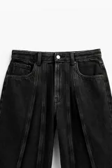 Pantalón de jean negro, corte ancho, con costuras expuestas al frente y en la espalda.