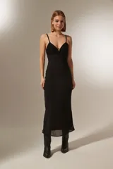 Vestido negro de tirantes finos con escote en V y diseño holgado.