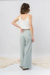 Pantalón negro de corte ancho y fluido, tiro medio con presillas para cinturón, bolsillos laterales funcionales y pinzas delanteras.