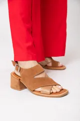 Sandalias de cuero color tostado, con plataforma de 1 cm y taco cuadrado de 6 cm. Presenta tiras cruzadas en el empeine, una tira ancha con abertura en el frente y pulsera con hebilla.