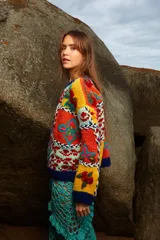 Sweater de lana tejido y bordado a mano con diseño de bloques de colores y motivos florales, de calce holgado, cuello a la base y puños acanalados. Talle único.