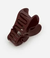 Hebilla para el pelo tipo garra con diseño de doble corazón en color bordó, fabricada en plástico resistente.