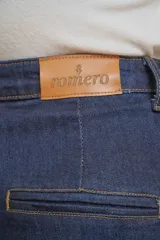 Jeans de mujer color azul oscuro, de pierna recta, con bolsillos ojal en la parte trasera. Incluye un cinturón bordado con diseño geométrico en tonos tierra.