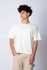 Remera color crudo de corte cuadrado y holgado, con cuello redondo y mangas cortas. Confeccionada en algodón pesado.