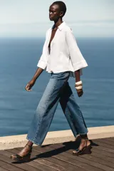 Sandalias negras con plataforma de madera, tacón de cuña y tira delantera con detalle de tachas doradas. Cierre mediante tira con pulsera al tobillo y acabado en punta cuadrada.