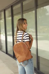 Mochila de cuero marrón con diseño austero y asas ajustables.