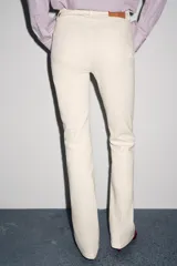 Pantalón de jean azul oscuro, de tiro bajo, corte slim fit y bootcut. Con cinco bolsillos y cierre frontal con cremallera y botón.