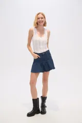 Minifalda negra de jean con diseño acampanado y volantes en el dobladillo.