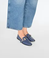 Mocasín azul con detalle de hebilla dorada.