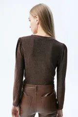 Remera marrón de tela elastizada de lurex, de calce al cuerpo, con cuello a la base y mangas estilo princesa.