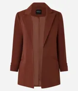 Blazer sastre femenino confeccionado en crepé color marrón, de modelo oversized y comprimento alargado. Sin estampa, posee bolsillos y detalle de pliegues en los puños.