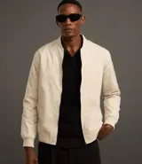 Campera bomber de poliéster color gris oscuro, con cuello alto, cierre frontal con cremallera, bolsillos laterales, mangas largas con puños ajustados y bajo con ajuste elástico.