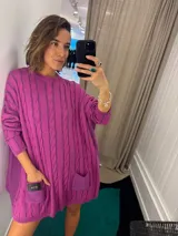 Sweater negro de punto con diseño de trenzas, corte holgado, mangas largas y bolsillos frontales. Tejido artesanalmente en Uruguay, con puños altos ajustados.