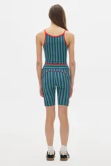 Top deportivo corto negro con cuello halter y tirantes finos en color crema.