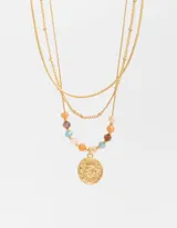 Collar corto triple dorado con cadenas de diferentes grosores. La cadena inferior tiene cuentas de colores y un dije redondo con diseño de sol.