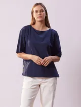 Blusa azul de algodón marca Erika, de manga corta amplia y cuello redondo. Presenta aberturas laterales con botones.