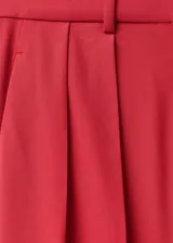 Pantalón de vestir rojo de corte wide leg, tiro alto, con detalle de pliegues, trabillas y forro interior.