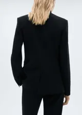 Traje sastrero rojo compuesto por blazer de corte recto con solapas de muesca y cierre de doble botón, chaleco con escote en V y pantalón de vestir de corte recto.