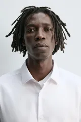 Camisa blanca de manga larga, corte slim fit, con cuello italiano y cierre frontal de botonadura.