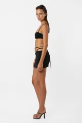 Minifalda negra de microfibra con tiro bajo, corte ajustado y frunces en el delantero. Incluye panty de microtul unida a la falda mediante tiras y argolla.