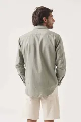 Camisa de lino color blanco, de corte regular, con cuello clásico y mangas largas.