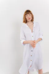 Vestido camisero midi color verde militar, de lino 100%, con silueta oversize, cuello camisero, mangas 3/4 con botón para ajustar y aberturas laterales.