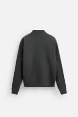 Cárdigan gris oscuro de tejido de mezcla de algodón con interior perchado, corte holgado, cuello pico, manga larga, bolsillos de vivo en la cadera, acabados en rib y cierre frontal de botonadura.