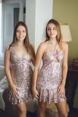 Vestido corto azul con estampado floral blanco, escote en V, breteles finos cruzados en la espalda, cut-outs laterales y volado en el ruedo.