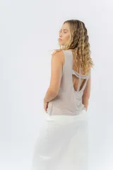 Musculosa color rosa metalizado, sin mangas, confeccionada en lino metalizado, con escote cerrado al frente y espalda abierta con lazo ajustable.