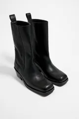 Bota de cuero negra, de media caña, con punta cuadrada, tirador trasero y tacón bajo.