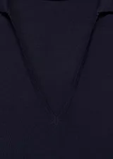 Vestido midi negro de punto fino, sin mangas, con cuello polo y corte ajustado.