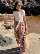 Pantalón de lino color terracota con bordado floral blanco.