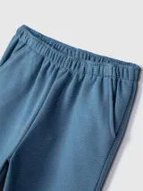 Pantalón de jogging celeste con textura acanalada, cintura elástica y bolsillos laterales.