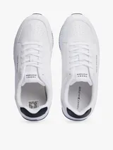 Zapatillas Tommy Hilfiger blancas de estilo running, con suela dentada fina y logo de la marca en el lateral.