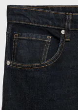 Pantalón de jean azul oscuro, corte wide leg, tiro bajo, con cinco bolsillos y cierre frontal con cremallera y botón.
