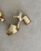 Sandalia de tacón con diseño brillante en color dorado, ideal para ocasiones especiales.