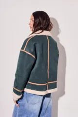 Abrigo oversize de poliéster color verde petróleo con forro de peluche en el cuello y puños.