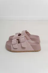 Sandalias color rosa con doble hebilla ajustable y suela marrón.