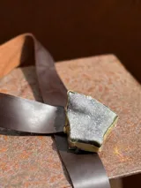 Cinturón de cuero color chocolate con hebilla de piedra natural enmarcada en metal dorado.