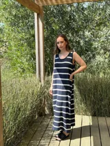 Vestido largo tejido a rayas horizontales azul marino y blancas, sin mangas, con cuello redondo y tajos laterales.