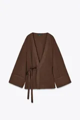 Kimono marrón de escote pico cruzado y manga larga amplia. Cierre con lazada interior y lateral.