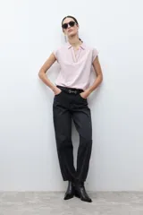 Remera de manga corta color rosa pálido, con cuello polo y escote en V con detalle de bordado en el borde.